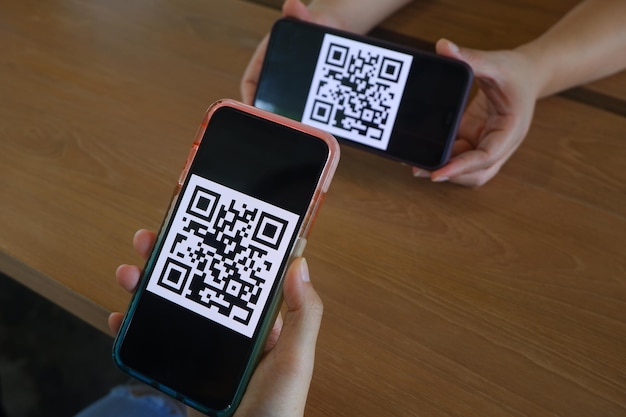 dos personas con teléfonos celulares con el código de código en ellos