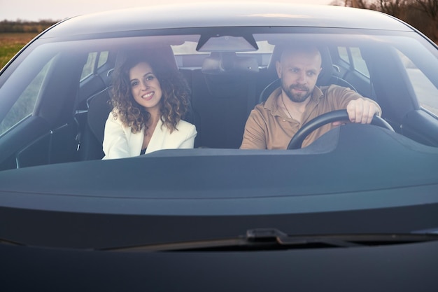 Dos personas viajando en coche y mirando a su alrededor