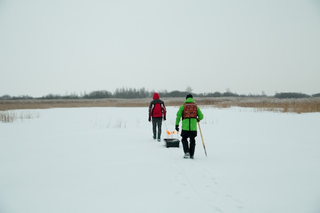 Dos pescadores con trineos en un pescador de invierno