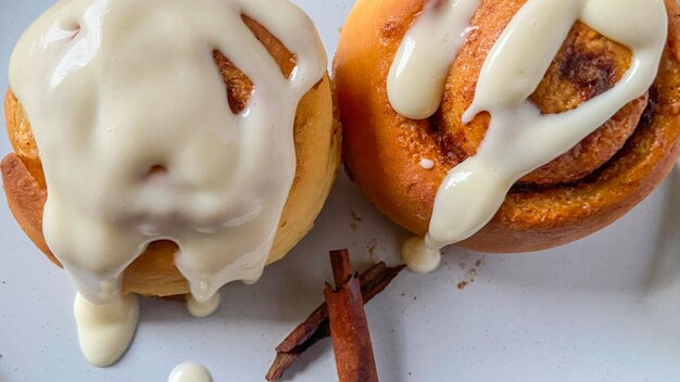 Foto dos piezas de deliciosos rollos de canela con crema encima