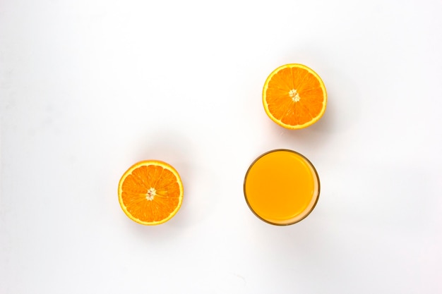 Dos piezas de naranjas jugosas con vaso de naranja aislado sobre fondo blanco Concepto de vista superior