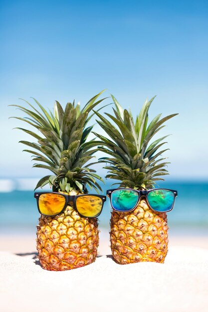 Dos piñas con gafas de sol de moda en un paraíso tropical