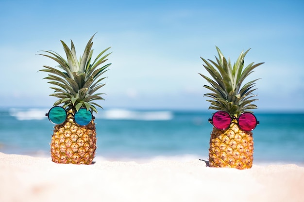 Dos piñas con gafas de sol de moda en la playa