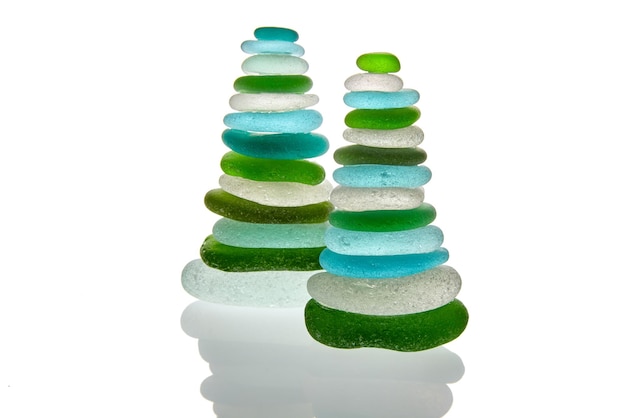 Dos pirámides de piedra de cristal de mar verde y azul cortada. Aislado sobre fondo blanco. piedras de equilibrio zen