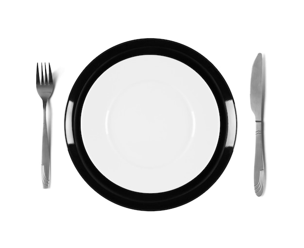 Foto dos platos blancos y negros apilados con tenedor y cuchillo aislados en fondo blanco