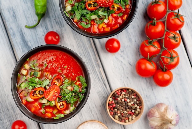 Dos platos de sopa de tomate gazpacho frío español tradicional sobre fondo de madera