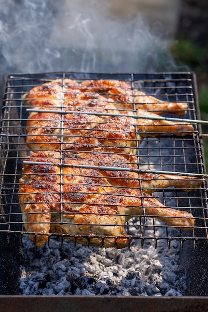 Dos pollos a la parrilla en un brasero de barbacoa de carbón