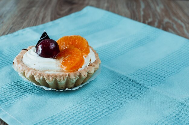 Dos postres, uno de chocolate con cerezas, el otro de crema blanca con ciruelas y mandarinas