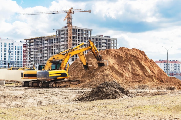 Dos potentes excavadoras trabajan al mismo tiempo en un sitio de construcción cielo azul soleado en el fondo Equipos de construcción para movimiento de tierras