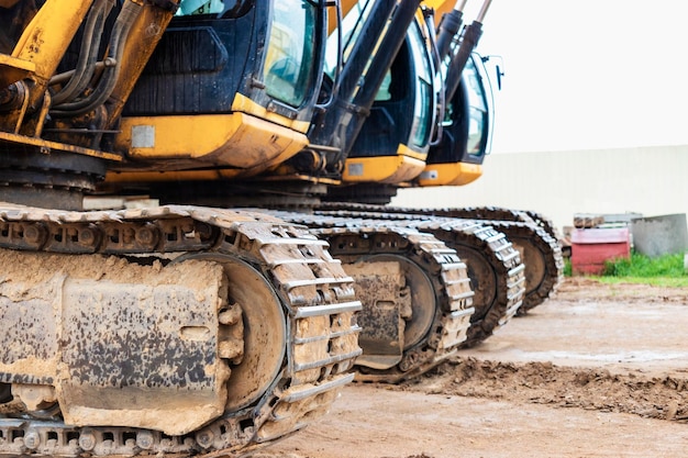 Dos potentes excavadoras trabajan al mismo tiempo en un sitio de construcción cielo azul soleado en el fondo Equipos de construcción para movimiento de tierras