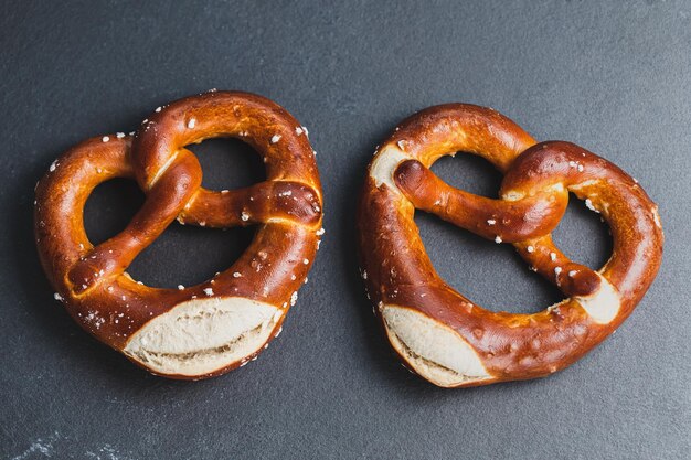 Dos pretzels suaves tradicionales de Oktoberfest sobre fondo negro