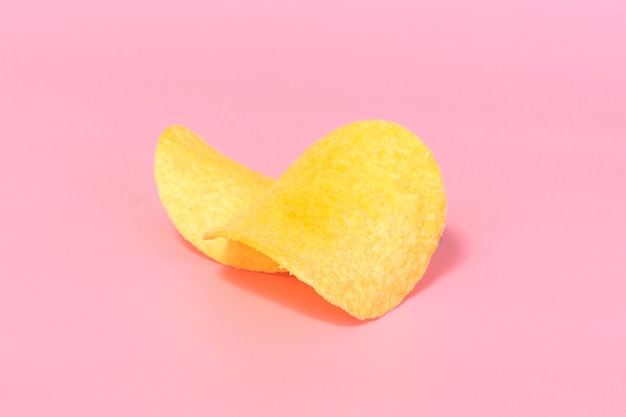 Un dos de primer plano de las papas fritas sobre un fondo rosa.