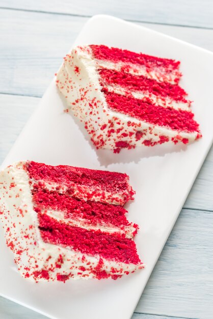 Dos rebanadas de pastel de terciopelo rojo en el plato blanco