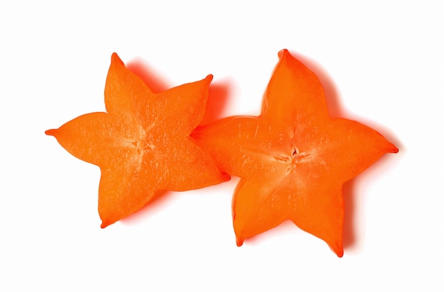 Dos rodajas de fruta de estrella fresca madura en vivo color naranja aislado sobre fondo blanco.