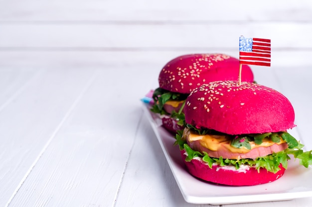 Foto dos sabrosas hamburguesas con banderitas americanas.
