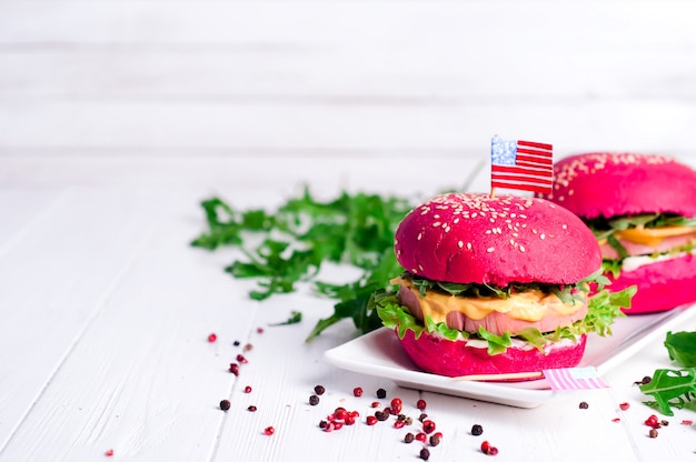 Dos sabrosas hamburguesas con banderitas americanas.