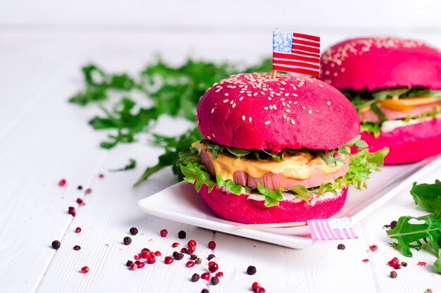 Dos sabrosas hamburguesas con banderitas americanas.