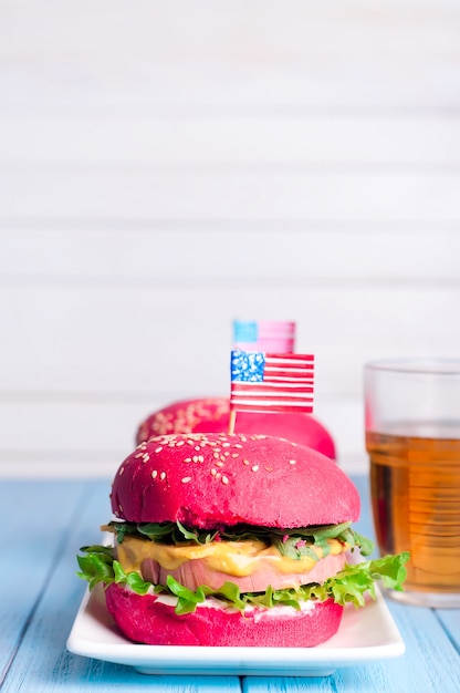 Dos sabrosas hamburguesas con banderitas americanas.