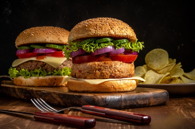 Dos sabrosas hamburguesas frescas en la mesa rústica de madera.