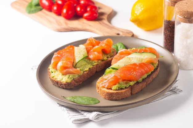 Foto dos sabrosos sándwiches abiertos de salmón con aguacate y pepino. desayuno saludable por la mañana. vista superior.