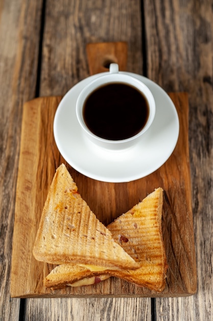 Dos sandwiches y café sobre un fondo de madera