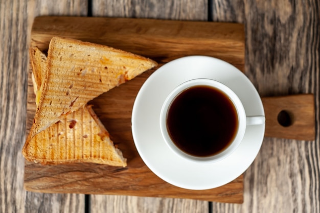 Dos sandwiches y café sobre un fondo de madera