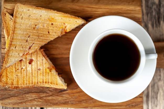 Dos sandwiches y café sobre un fondo de madera