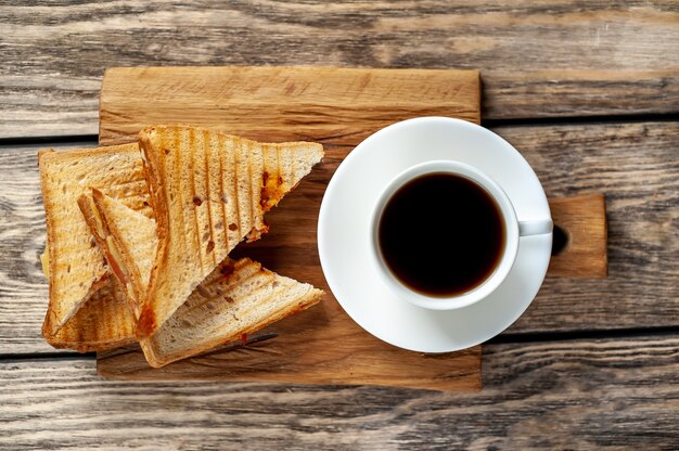 Dos sandwiches y café sobre un fondo de madera