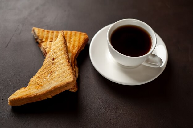 Dos sandwiches y café sobre un fondo de piedra.