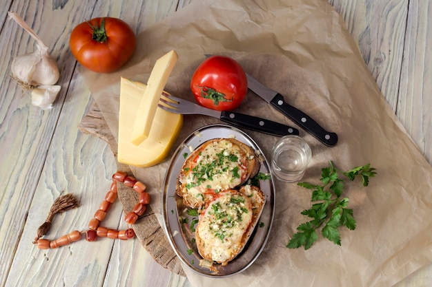 Dos sándwiches calientes con queso y tomates en un primer plano de la mesa de madera