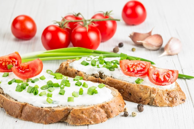 Dos sándwiches con queso crema y tomates