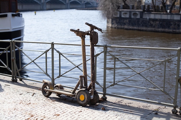 Dos scooters eléctricos de alquiler ahogados en el soporte de barro en el terraplén de la ciudad vándalos arrojan scooters i