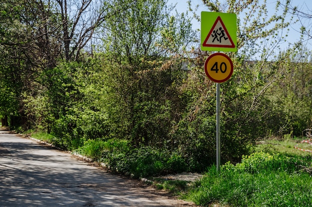 Dos señales de tráfico en un pilar señal de precaución para niños y señal de límite de velocidad 40