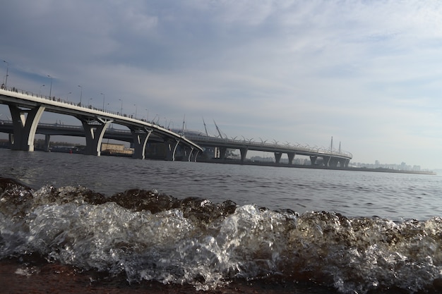 Dos serpenteantes puentes de carretera sobre el ancho río con la niebla vista futurista