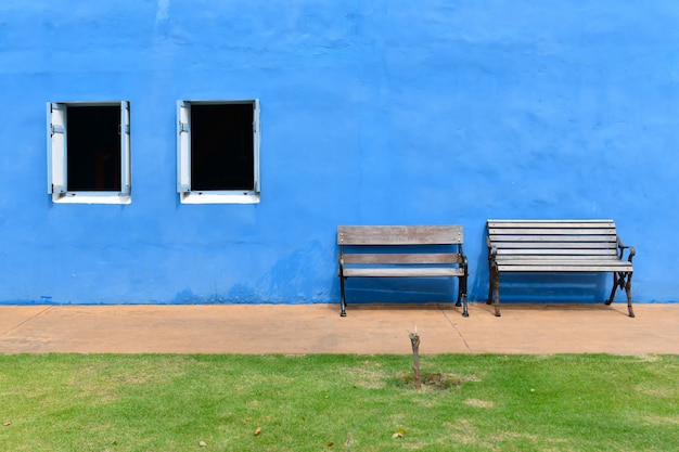 Foto dos sillas de madera frente a la pared de yeso azul.