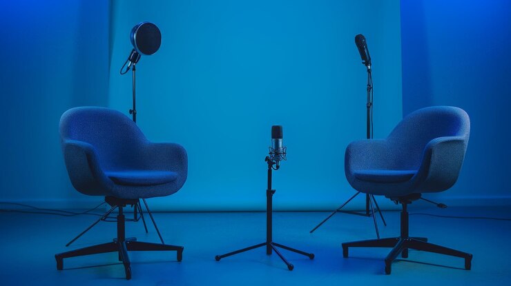 Dos sillas y micrófonos en la sala de podcasts o entrevistas en fondo oscuro como un amplio estandarte para conversaciones de medios o conceptos de streamers de podcasts
