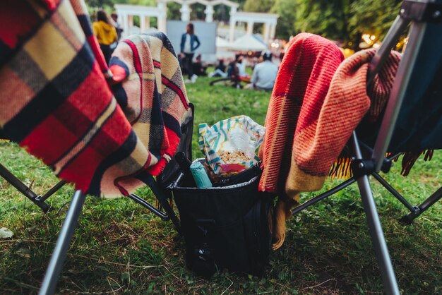 Dos sillas plegables con bolsa de enfriamiento con cerveza y bocadillos en cine al aire libre