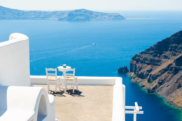 Dos sillas en la terraza con vista al mar. Arquitectura blanca en la isla de Santorini, Grecia. Concepto de destinos de viaje