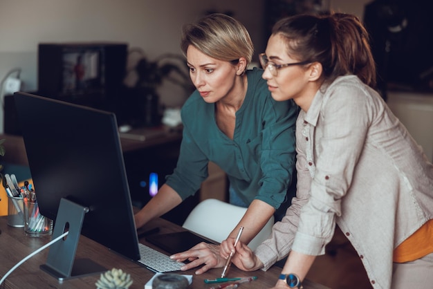 Dos socias de negocios trabajando juntas en la oficina en casa.