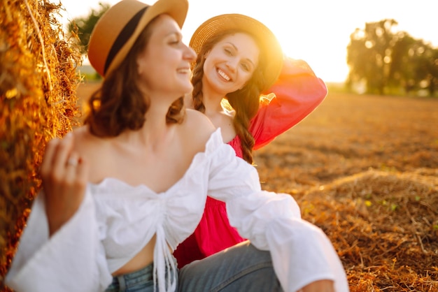 Dos sonriente joven descansando cerca del pajar Concepto de moda Naturaleza vacaciones relax y estilo de vida