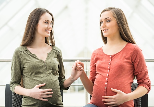 Dos sonrientes mujeres embarazadas en la reunión en la clase prenatal.