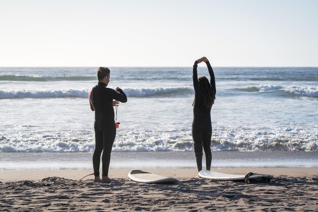 Dos surfistas en la playa estirándose antes de montar las olas en La Serena