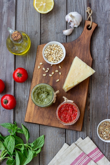 Dos tarros de cristal con pesto rojo y pesto de albahaca. Cocina Nacional. Alimentación saludable. Comida vegetariana.