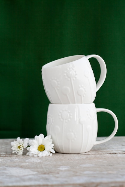 Foto dos tazas blancas con flor blanca