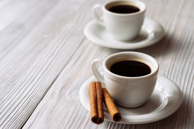 Dos tazas de café en una mesa de madera blanca