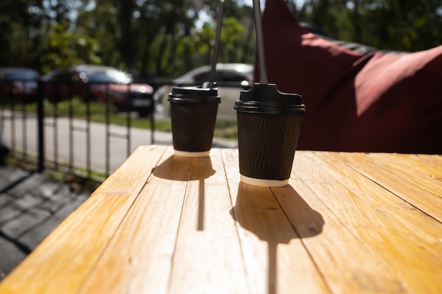 Dos tazas de café de papel en la mesa al aire libre