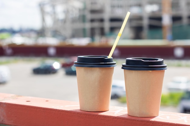 Dos tazas de café de plástico en el fondo de la ciudad.