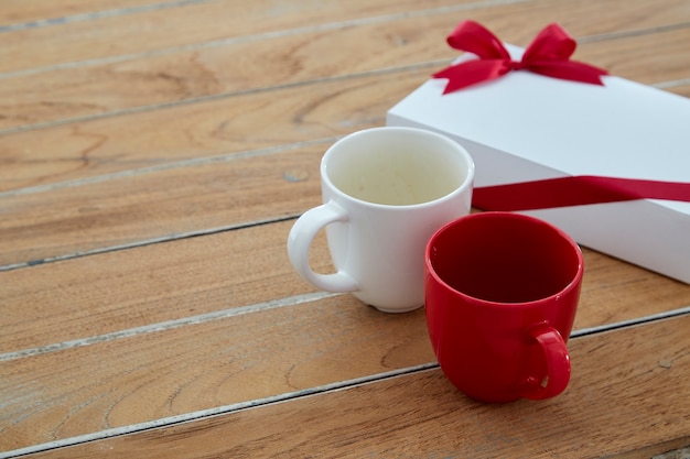 Dos tazas de café rojo y blanco en madera