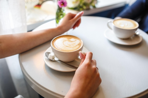 Dos tazas de café sobre una mesa en un café