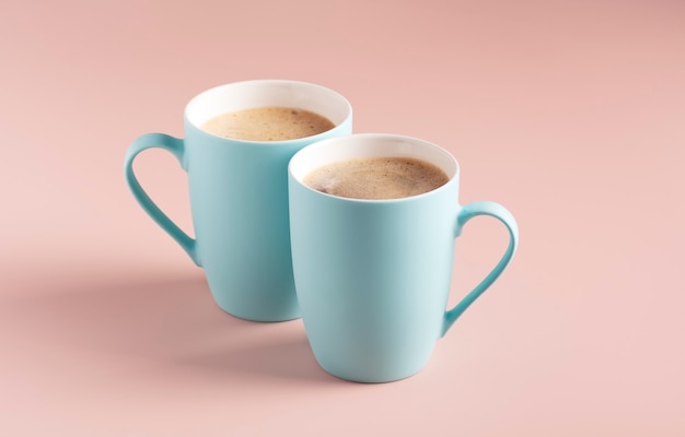 Foto dos tazas de color azul claro con soporte de café sobre un fondo polvoriento